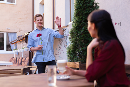 Handsome man. Handsome blonde-haired man wearing stylish jeans shirt coming for date with flowerの写真素材