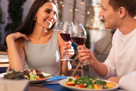 Nice earrings. Stylish woman wearing nice earrings drinking wine with her boyfriendの写真素材