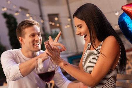 Fun with man. Appealing dark-haired woman having fun with her man while celebrating her birthday in restaurantの写真素材