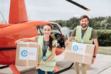 Jolly two volunteers laughing and carrying boxesの写真素材