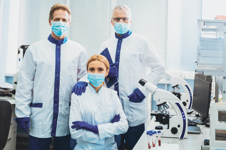 Concentrated female person crossing arms on chest while sitting in the laboratoryの写真素材