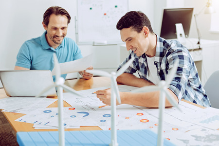 Smiling engineers. Positive skilled young engineers having a productive day while working at their...