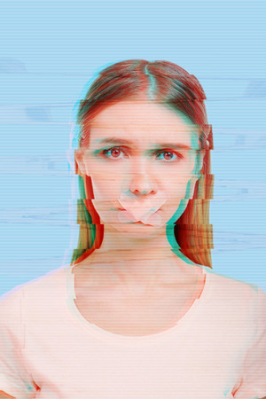 No words. Sad unhappy young woman suffering from domestic violence and standing with a plaster on her lipsの写真素材