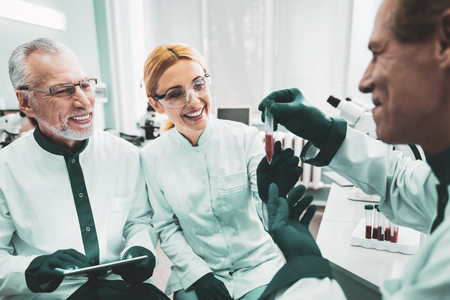 Trio of workers. Trio of smiling professional medical workers feeling happy while enjoying completing challenging taskの写真素材