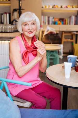 Delighted joyful woman rubbing her hands while applying creamの写真素材