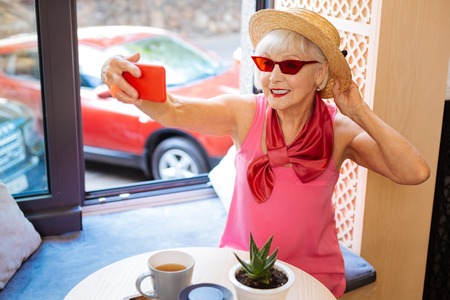 Positive aged woman smiling while posing for a photo