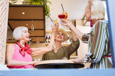 Happy nice women drinking cocktails while meeting in the cafeの写真素材