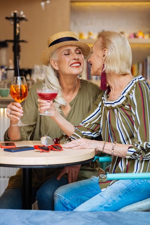 Nice lesbian couple sitting in the restaurant while having a dateの写真素材