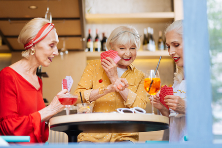 Happy nice women having fun together while playing card gamesの写真素材
