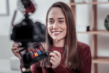 Buy this. Popular creative video blogger advertising new cosmetics brand showing their eye shadows