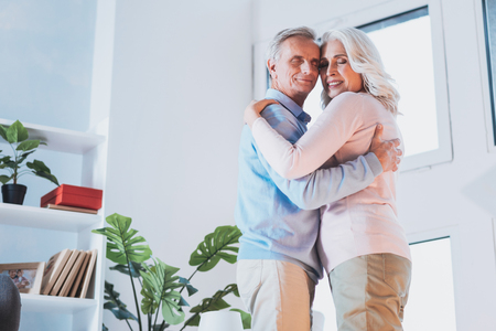 Joyful couple dancing at home while celebrating their anniversaryの写真素材