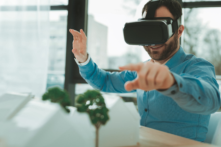 3d reality. Happy cheerful man looking into 3d glasses while working on his projectの写真素材