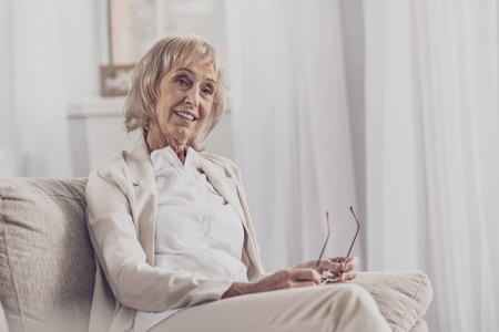 Appealing woman. Appealing elderly woman with facial wrinkles feeling thoughtful while thinking...