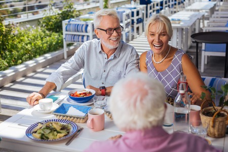 Pleasant communication. Joyful happy couple sitting in the restaurant while speaking with their...