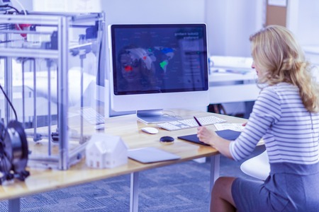 News review. Young female person staring at computer while analyzing data