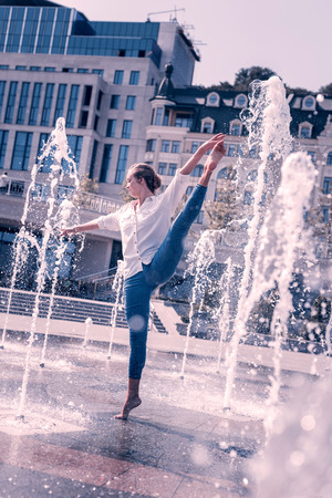 My dance. Professional female dancer standing barefooted in the fountain while dancingの写真素材