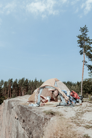 Tent camp. Couple of young and active backpackers feeling amazing after waking up in nice tent camp near the lakeの写真素材
