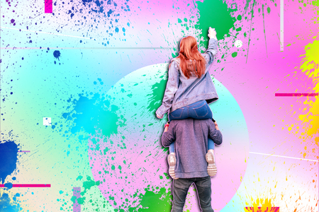 Little vandalism. Young experienced vandals standing in front of the wall and wearing casual clothes while drawing graffitiの写真素材