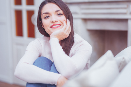 Portrait of gorgeous attractive charismatic woman propping her chin on hand while looking at you and feeling pleasedの写真素材