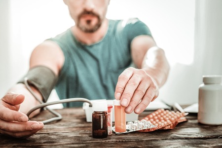 Selective focus of small bottles standing on the table in front of a nice adult manの写真素材