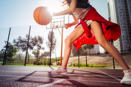 One more player. Active girl playing basketball and spending day alone with pleasureの写真素材