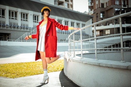 Attractive model coquettishly lifting up her leg in white long socksの写真素材