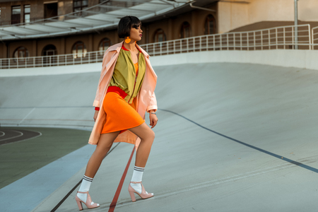 Resolute strong independent female stepping in bright future wearing pink high heels and white socksの写真素材