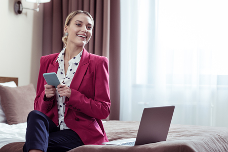 Beautiful elegant businesswoman using phone before going to important business meetingの写真素材