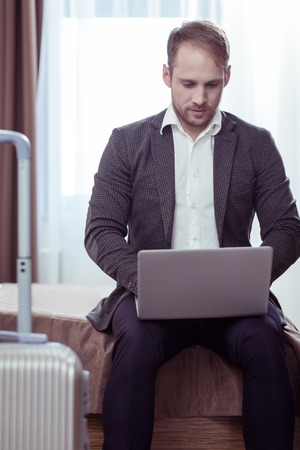 Bearded blonde-haired businessman writing business letters after business flightの写真素材