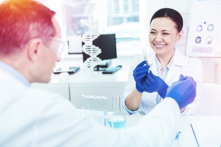 Cheerful positive woman smiling while working in the laboratoryの写真素材