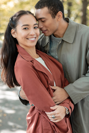 Love my partner. Handsome male person embracing his partner while Kissing  sweet cheekの写真素材