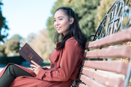 Thoughtful brunette female keeping smile on her face while enjoying the natureの写真素材