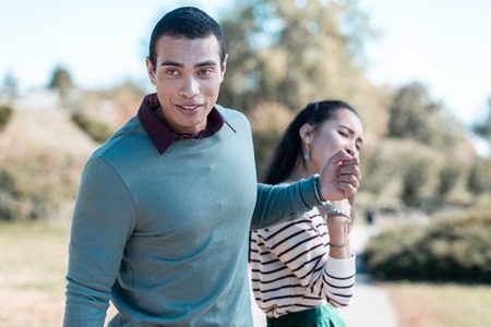 Lovely couple. Unhappy girl stretching her arm while trying to get freedomの写真素材