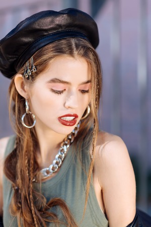 Young model. Top view of beautiful young dark-haired model wearing dark cap and hair slidesの写真素材