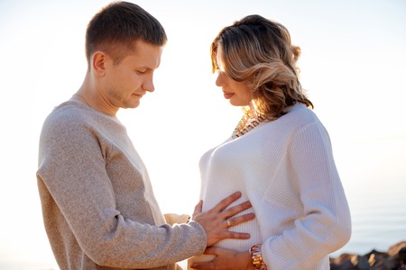 Having a child. A man and a woman touching the pregnant woman belly