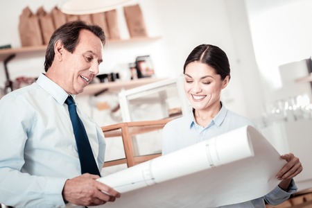 Optimization plan. Nice positive people discussing their business while looking at the drawingの写真素材