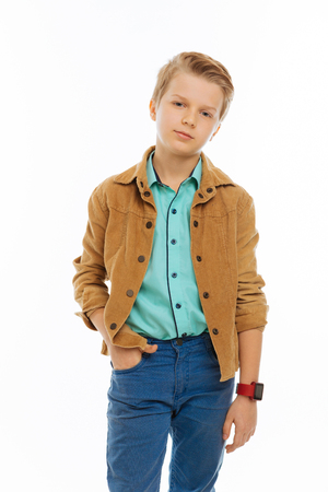 Stylish kid. Nice serious boy putting a hand in his pocket while looking at youの写真素材