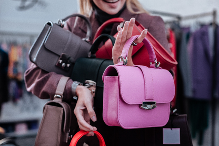 Owner of store. Smiling successful prosperous owner of concept store presenting new leather bagsの写真素材