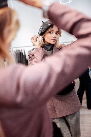 Polo and beret. Shopaholic wearing grey polo neck and nice black beret while standing in front of mirrorの写真素材