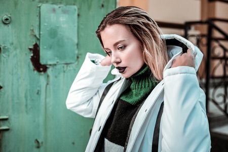 Winter clothes. Blue-eyed fashionable beautiful model with dark lips wearing stylish winter clothes