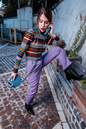 Posing with phone. Professional experienced red-haired photo model holding phone while posingの写真素材