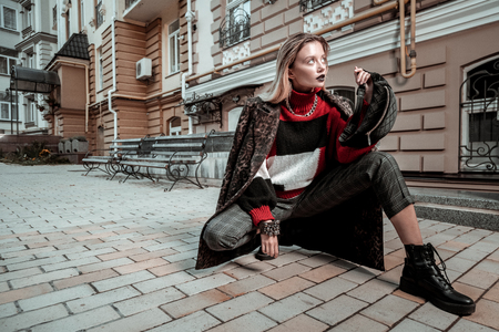 Model posing. Blonde-haired professional photo model wearing nice clothes posing outside the streetの写真素材