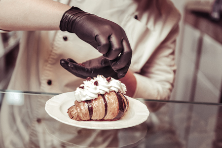 Sweet masterpiece. Top view of a beautifully decorated croissant lying on the plateの写真素材