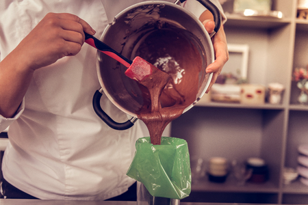 Almost ready. Close up of bakery dough in the bowl being put into the pastry bagの写真素材