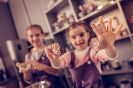 Childs hands. Selective focus of a hand of the nice cute pleasant girl being in the doughの写真素材