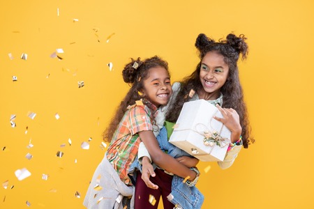 Happy birthday to you. Happy joyful girl hugging her beloved sister while congratulating her on birthdayの写真素材