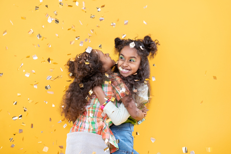 Sisters love. Delighted positive girls hugging each other while expressing their love to each otherの写真素材