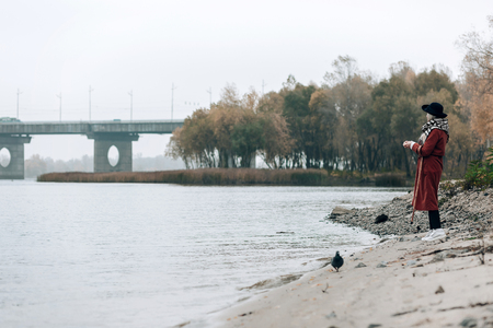 Nature inspired. Stylish mature woman looking at water and dreaming about summerの写真素材