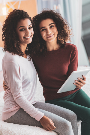 Two beautiful sisters looking alike feeling wonderful while spending their weekend togetherの写真素材