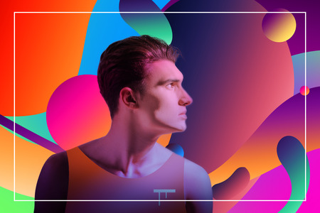 Pensive creative guy posing on colorful background and looking asideの写真素材